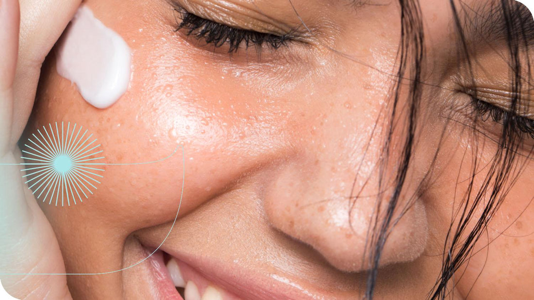 close no rosto de uma mulher que está sorrindo enquanto aplica o Creme Nutritivo Facial da Intua Beauty em seu rosto