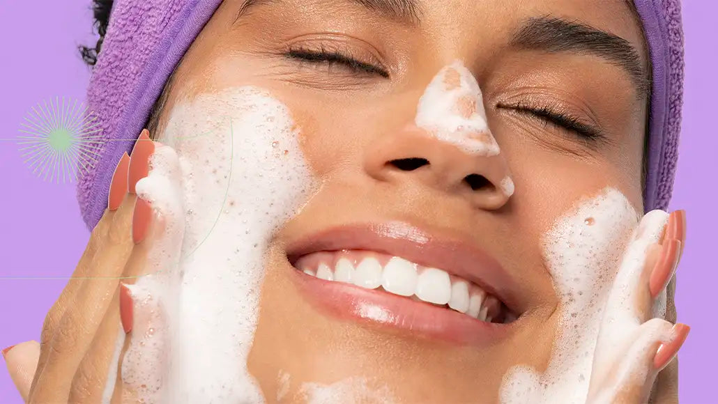 mulher sorrindo enquanto lava o rosto com a Espuma de Limpeza Facial da Intua