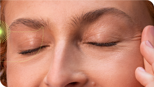 Mulher com os olhos fechados passando as mãos sobre suas têmporas.