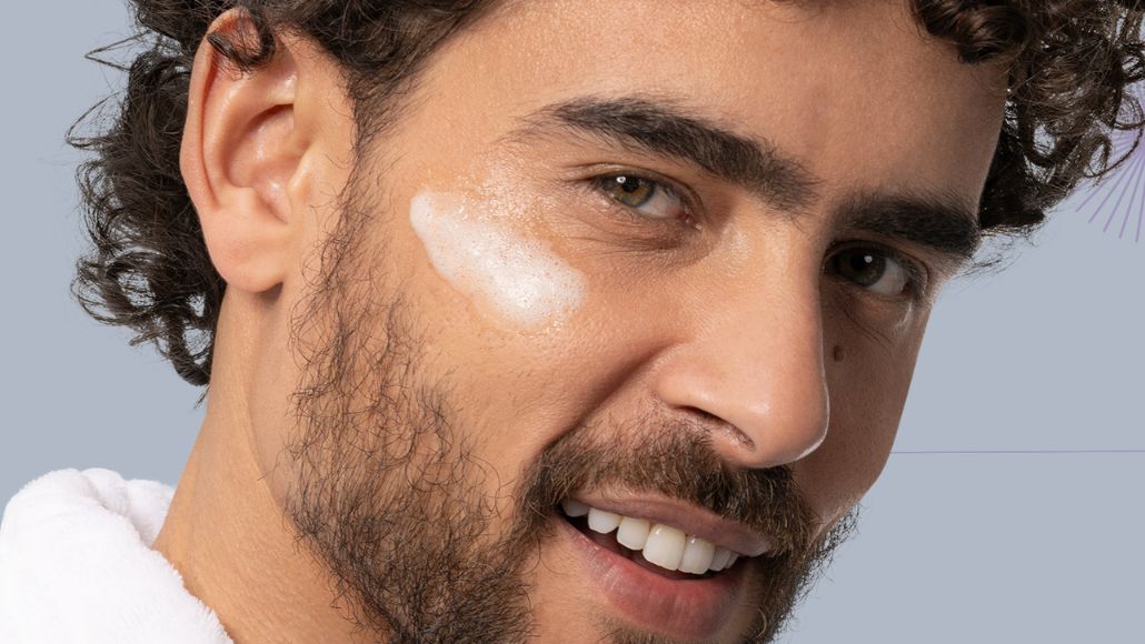 Homem com a Espuma de Limpeza Facial da Intua aplicada em sua bochecha.