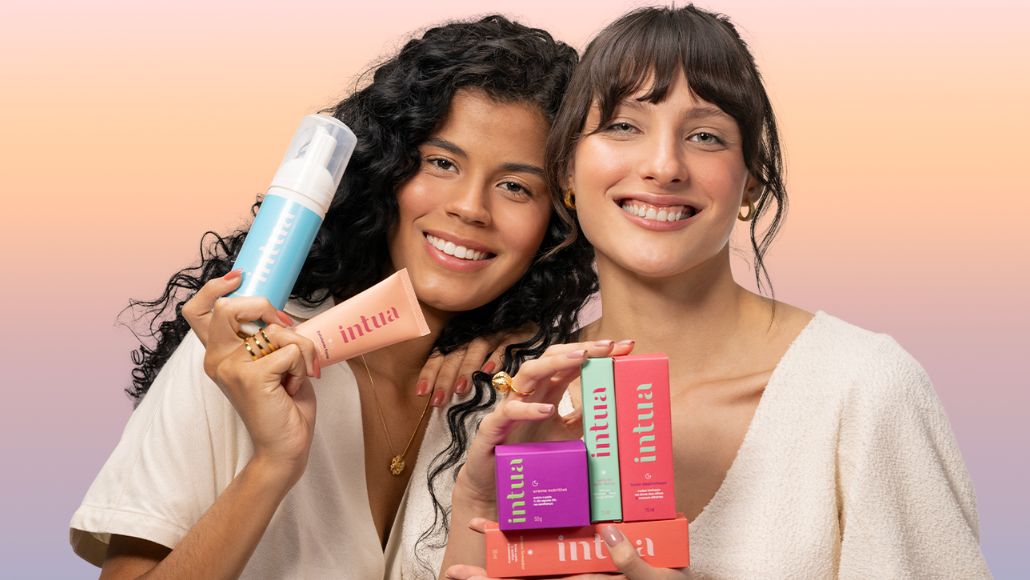 Duas mulheres sorrindo segurando produtos Intua.