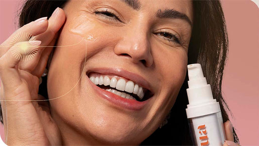 mulher sorrindo aplicando o Sérum Firmador na Intua em seu rosto