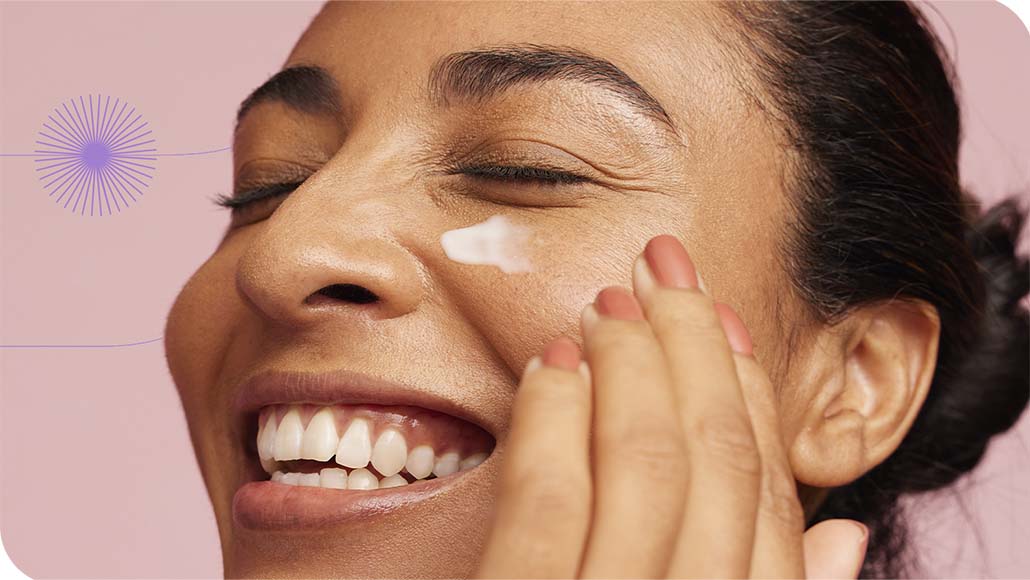 mulher sorrindo enquanto passa o Creme Nutritivo Facial da Intua em sua bochecha