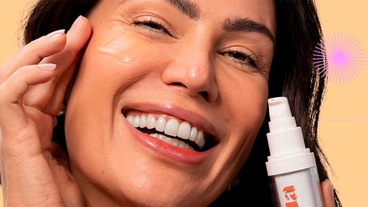 Mulher sorrindo ao aplicar o Sérum Firmador da Intua Beauty nas maças de seu rosto