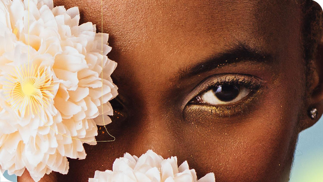 close na parte superior do rosto de uma mulher que está tapando um de seus olhos com uma flor