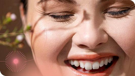 mulher sorrindo muito feliz com os olhos fechados e a sombra de uma planta está projetada sobre seu rosto