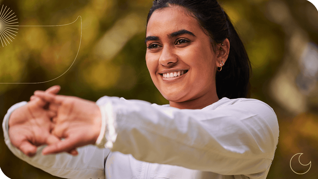 mulher sorrindo enquanto se alonga ao ar livre